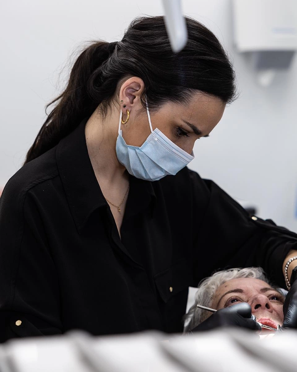 Dentista atendendo uma paciente no consultório